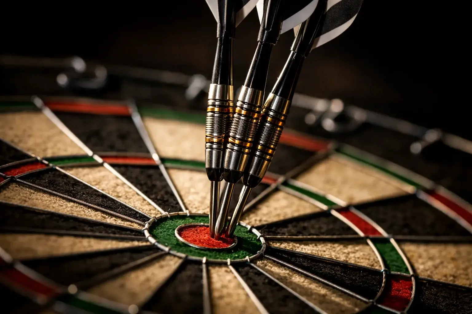 Drei Darts stecken im Bullseye einer Dartscheibe unter dramatischer Beleuchtung